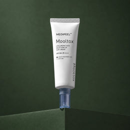 Crème Solaire Teintée Hyaluronic Acid Layer Mooltox SPF50+ PA++++ MEDIPEEL – vue 2 sur fond vert profond.