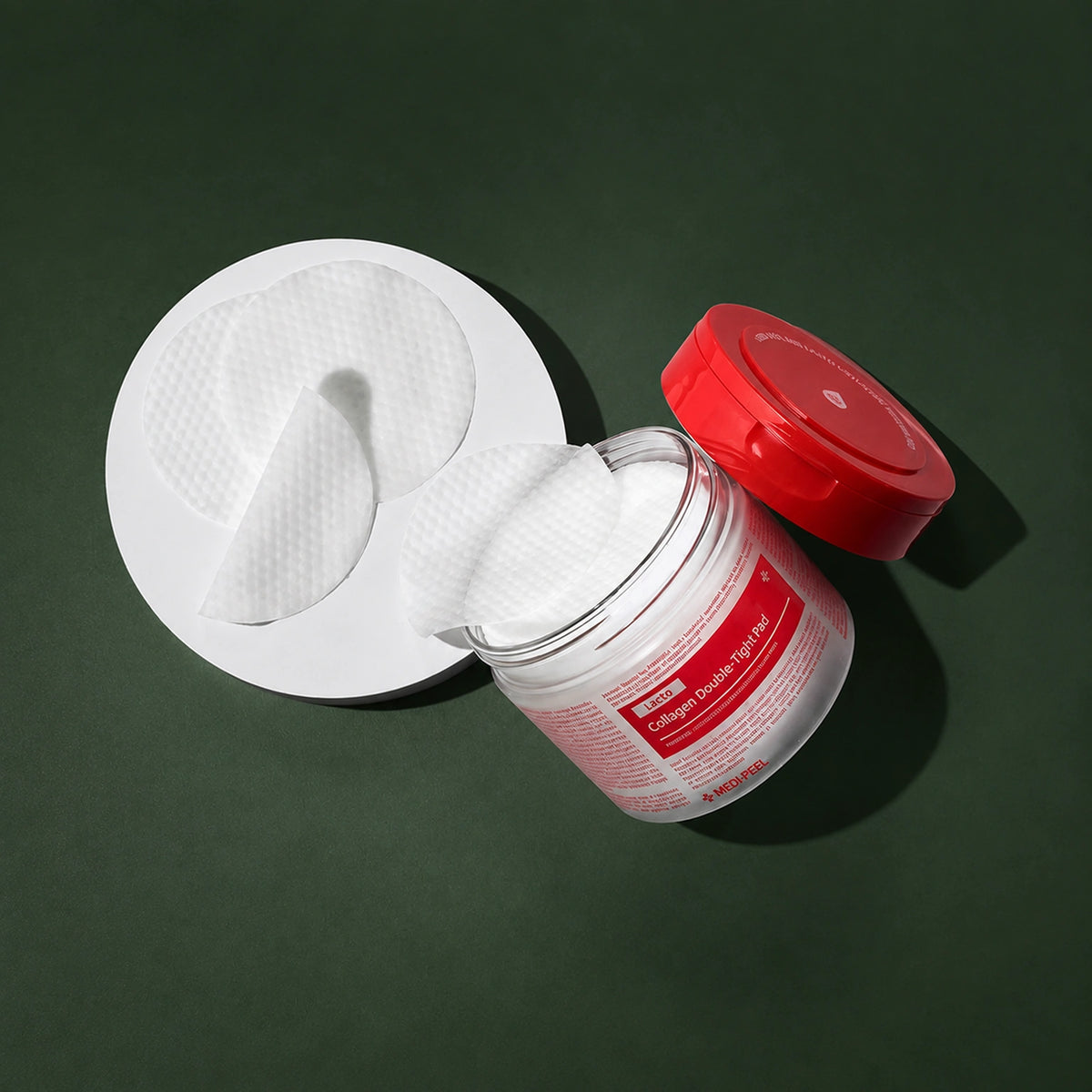 Pads Tonifiants Red Lacto Collagen Double Tight MEDIPEEL – vue 3 sur fond vert profond.