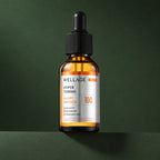 Ampoule Éclat Niacinamide et Acide Tranexamique WELLAGE sur fond vert profond